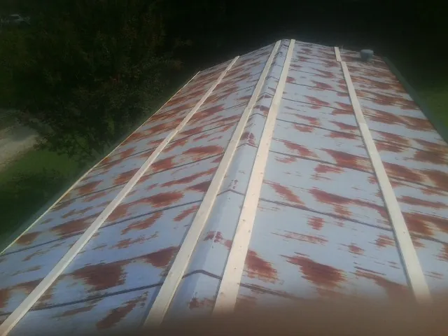 Rusted metal roof panels with new wood purlins before replacement — Storm Damage Roof Repair in Maxbass by Roofing Brothers